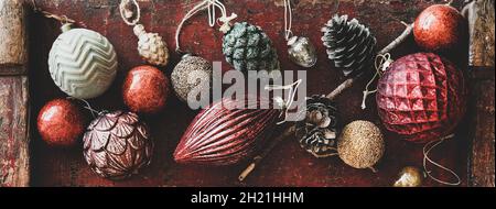 Flat-lay of Christmas decorative toys over red wooden background, close-up