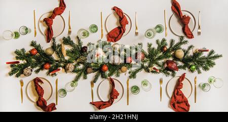 Flat-lay of festive Christmas table setting with dinnerware and decorations Stock Photo