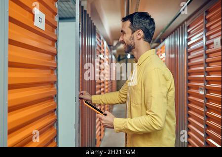 Profile of happy man opening garage door Stock Photo