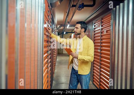 Man touching garage door in storage room Stock Photo