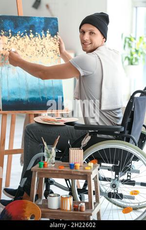 Young handicapped artist painting in workshop Stock Photo
