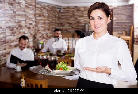 Female waiter showing country restaurant Stock Photo