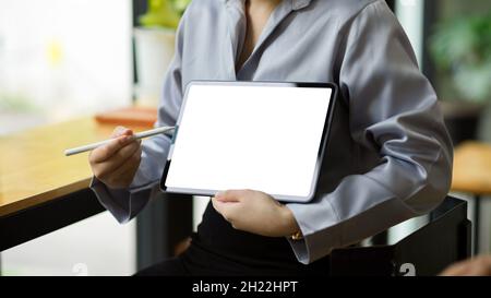 Cropped image of businesswoman shows and explains the information on tablet screen to her coworker. tablet blank screen mockup. Stock Photo