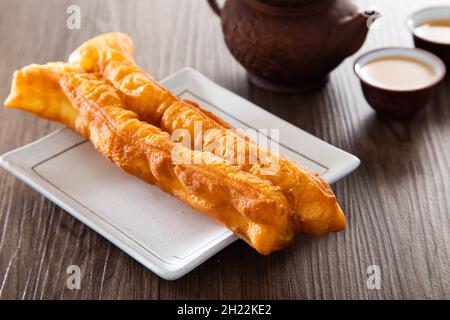 Youtiao (Chinese fried breadstick). Long golden brown deep fried dough strip. Stock Photo