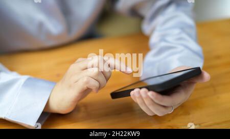Close-up female hands tapping on smartphone screen. female using smart mobile phone to ordering delivery food on the apps. Stock Photo