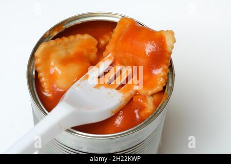 Ravioli in tin and plastic fork, ready meal with fork Stock Photo
