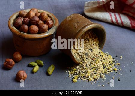 Dukkah, Arabic spice mixture in clay pots and nuts Stock Photo