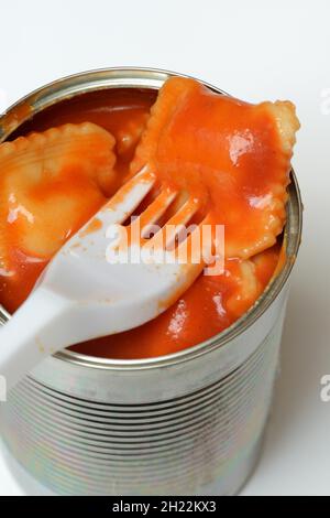 Ravioli in tin and plastic fork, ready meal with fork Stock Photo