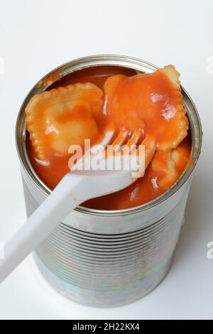 Ravioli in tin and plastic fork, ready meal with fork Stock Photo