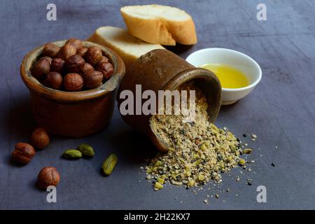 Dukkah, Arabic spice mixture in clay pots, nuts and bowls with olive oil Stock Photo