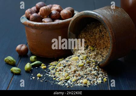 Dukkah, Arabic spice mixture in clay pots and nuts Stock Photo