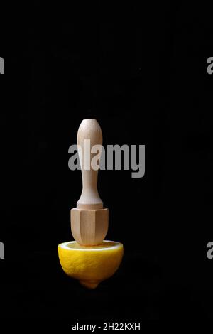 Lemon and lemon squeezer against a black background Stock Photo