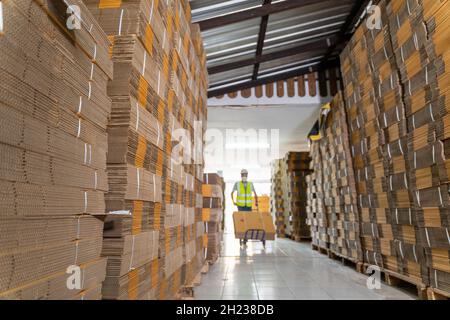 Select focus of Row of brown boxes, Warehouse workers characters unloading boxes in warehouse. Stock Photo