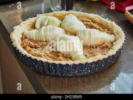 Cake with pears and peaches in metal mold is ready for baking in an electric oven Stock Photo