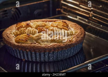 Baked cake with pears and peaches in metal form in an electric oven Stock Photo