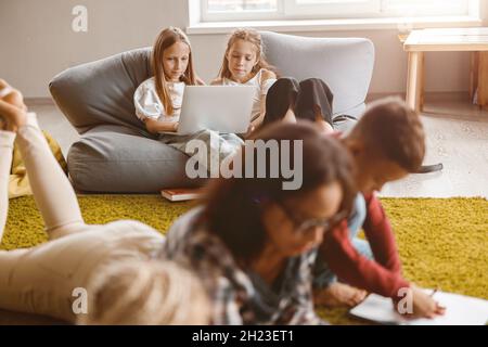 Children using laptop while sitting in classroom Stock Photo