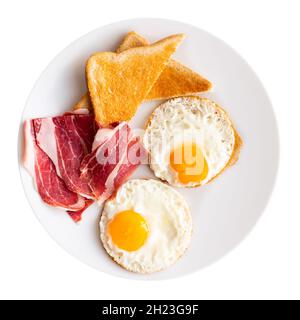 Fried eggs with slices of ham and wheat bread toasts Stock Photo