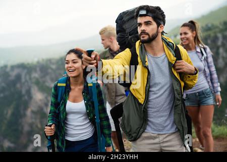 Group of fit healthy friends trekking in the mountains Stock Photo