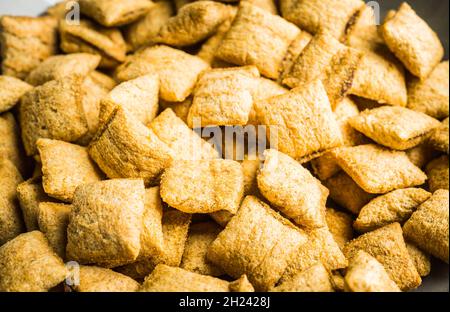 Wholegrain pillow cereals in bowl on the rustic background. Selective focus. Shallow depth of field. Stock Photo