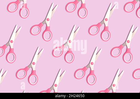 Pattern made of pink scissors on a purple pastel background. Creative layout. Stock Photo