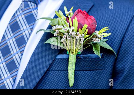 Wedding boutonniere of the groom on a blue suit. Wedding floristry. Ready for wedding ceremony. Close-up Stock Photo