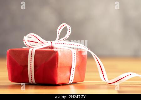 Close up photo of  red gift box  with white ribbon. Love, gift and present concept. Stock Photo