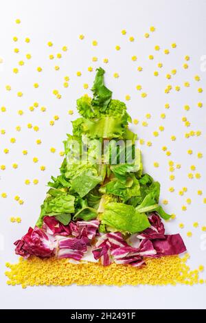 Christmas tree made from green salad products, cabbage, raw pasta. View from above Stock Photo