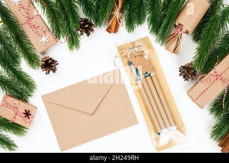 flat lay of Christmas stationery, craft envelope, set of craft pens with decorations from fir branches and gift boxes Stock Photo