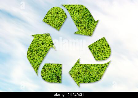 Recycling icon mocked up of grasses on foreground. Symbol of zero waste concept. Stock Photo