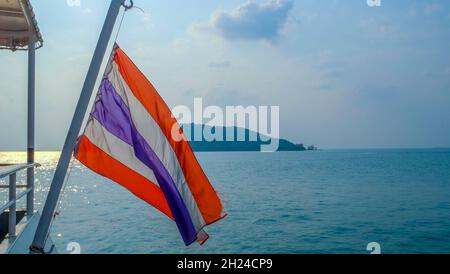 Thai flag over the passengers at a port in Ko Pha-ngan, Thailand Stock Photo