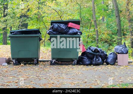 Dumpsters being full with garbage in the park. Garbage waste lots junk dump. Pin ollution from waste. Stock Photo