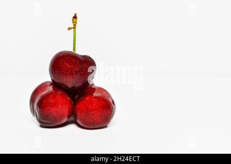 Group of three cherries on white background Stock Photo
