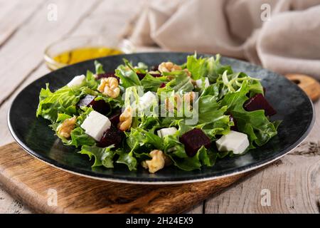 Beetroot salad with feta cheese,lettuce and walnuts on rustic wooden table Stock Photo