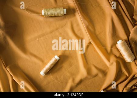 Sewing background with tailor equipment on the peach colored cloth. Selective focus. Stock Photo