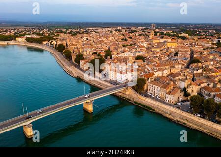 Cityscape of Arles, southern France. Tiled roofs of buildings and Rhone River visible from above. Stock Photo