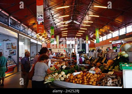 Shoppers looking at the fresh produce for sale in the indoor market, Olhau, Algarve, Portugal, Europe. Stock Photo