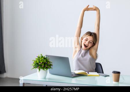 Young businesswoman is relaxing in office stretching her body. Stock Photo