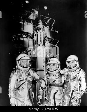 1961 -- The first three Americans in space, Mercury astronauts, from the left, John H. Glenn Jr., Virgil I. (Gus) Grissom and Alan B. Shepard Jr. standing by Redstone rocket in their spacesuits. Stock Photo