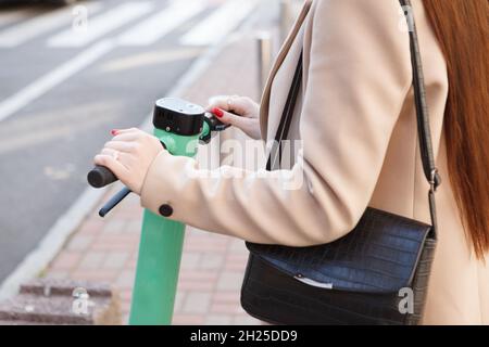 Cropped close up of a woman using electric scooter to travel in the city Stock Photo