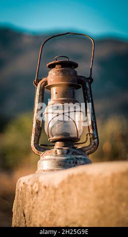 kerosene lamp : a vintage oil lamp in a mountain background with blue sky. Stock Photo