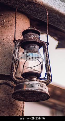 Old rusty kerosene lamp hanging on a metal grid in Morocco village. Stock Photo