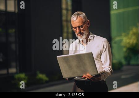 Serious businessman focused on reading an email outside Stock Photo