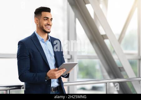 Portrait Of Handsome Middle Eastern Businessman Using Digital Tablet At Airport Stock Photo