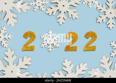 Happy new year 2022. Golden Numbers 2022 with snowflakes.New Years Eve celebration concept background over blue background. New Years Eve celebration