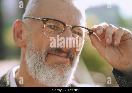 Mustached bearded male in round spectacles looking ahead Stock Photo