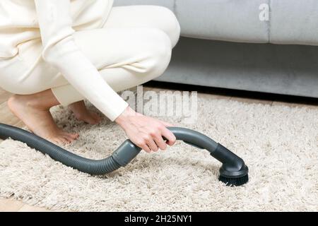 Woman is vacuuming bedroom carpet. Stock Photo
