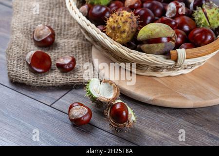 Chestnuts in a basket on a wooden background. Stock Photo