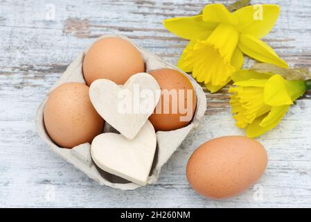 Easter eggs, Heart and daffodil lying on wood Stock Photo