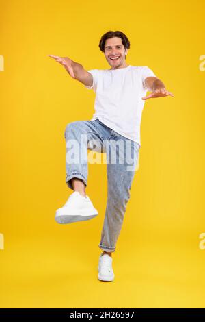 Happy young man jumping and dancing at studio Stock Photo