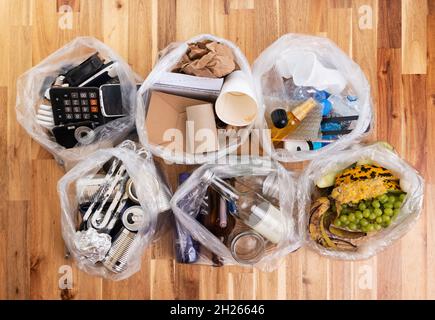 Top view photo of segregated waste materials laid on wooden background. waste management concept Stock Photo